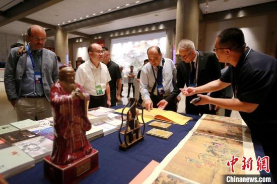 　　中外嘉賓在會場內翻閱中國典籍。梁犇 攝